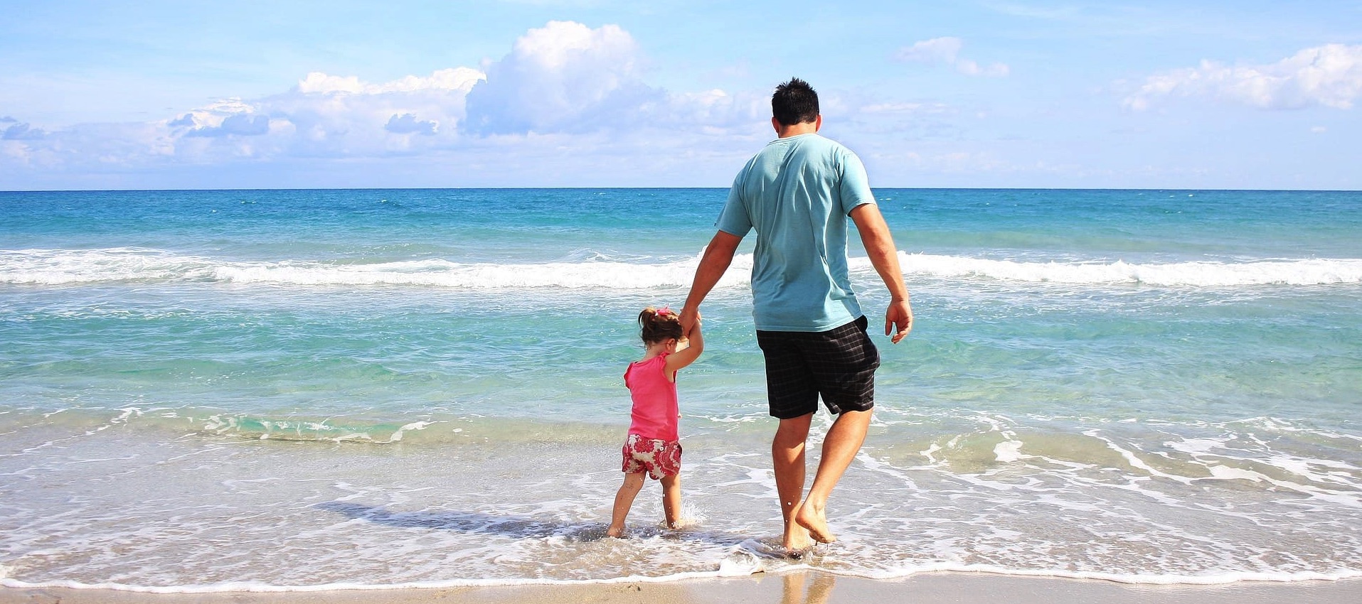 father and daughter on beach | summer health insurance